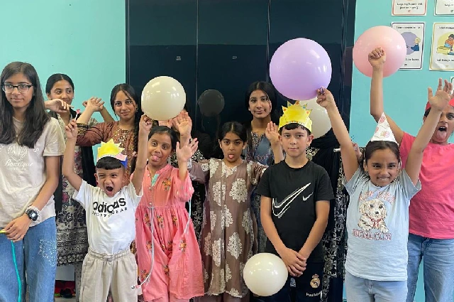 Children laughing and celebrating with balloons at Creative Learning Academy